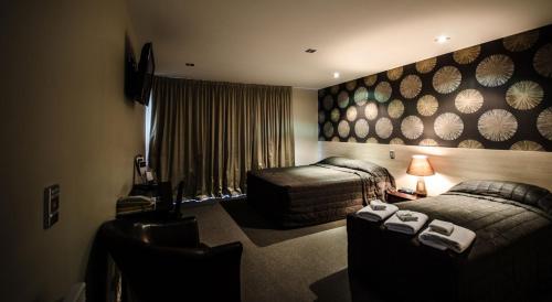 a hotel room with two beds and a couch at Racecourse Hotel and Motor Lodge in Christchurch