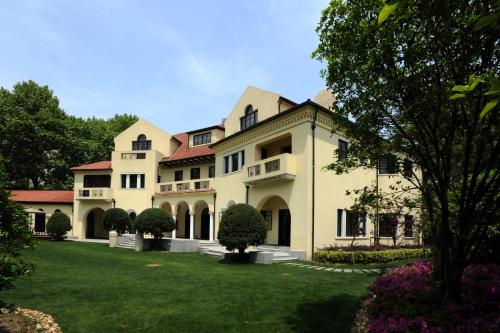 um grande edifício branco com um relvado em Shanghai Fenyang Garden Boutique Hotel em Xangai