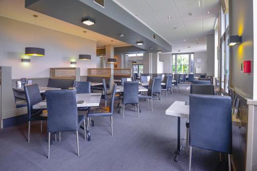a dining room with tables and chairs in a building at Racecourse Hotel and Motor Lodge in Christchurch