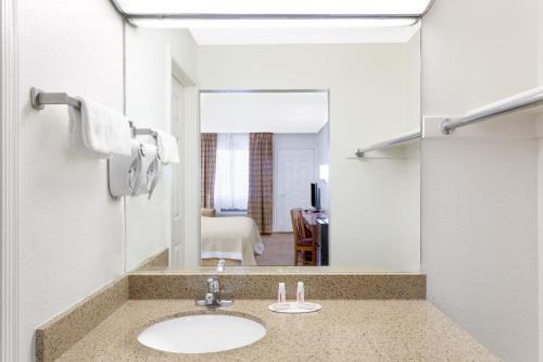 a bathroom with a sink and a mirror at Days Inn by Wyndham Kingman West in Kingman