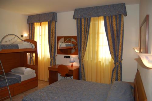 a bedroom with two bunk beds and a desk at Hotel Anfora in Capoliveri