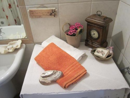 a bathroom with a table with a towel and a clock at House Antaya in Nikiti