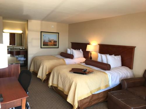 a hotel room with two beds and a couch at Norfolk Country Inn and Suites in Norfolk