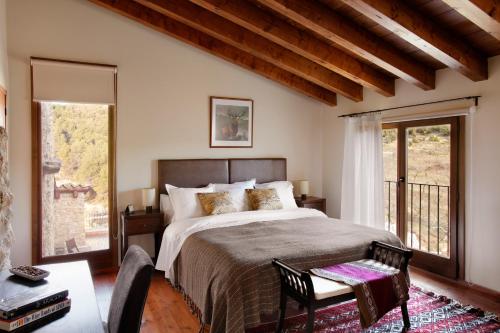a bedroom with a large bed and a balcony at Hotel Mas de la Serra in Fuentespalda