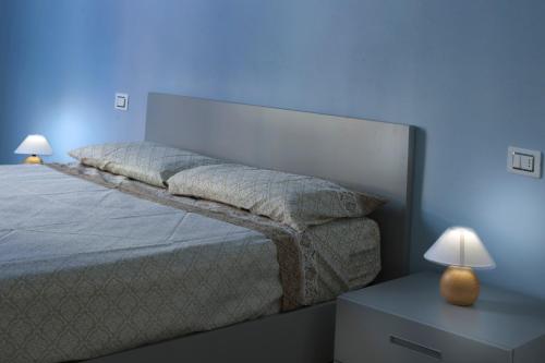 un letto in una camera blu con due lampade di Residenza Intra Lago Maggiore a Verbania