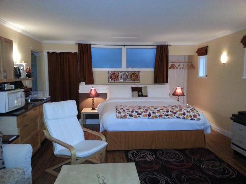 um quarto de hotel com uma cama e uma cadeira em Above the Inlet em Sechelt