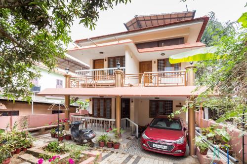 a house with a red car parked in front of it at Thoms Beach Homestay in Alleppey