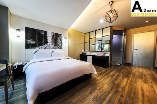A2 Hotel Desingers في Yesan: غرفة نوم بسرير ابيض كبير وحمام