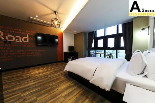 a hotel room with a bed and a flat screen tv at A2 Hotel Desingers in Yesan
