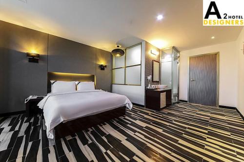 a bedroom with a large white bed and a striped carpet at A2 Hotel Desingers in Yesan