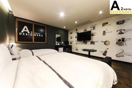 a bedroom with a white bed and a wall with instruments at A2 Hotel Desingers in Yesan