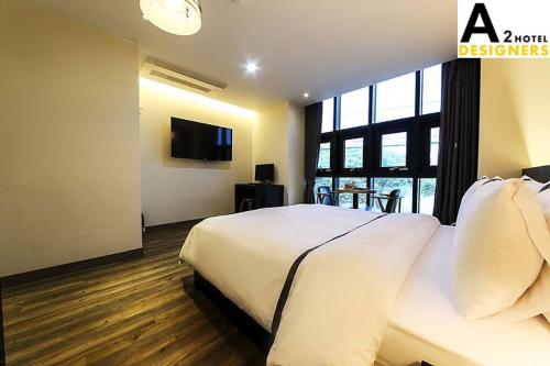 a bedroom with a white bed and a large window at A2 Hotel Desingers in Yesan