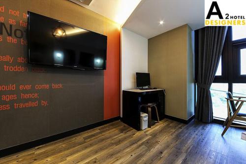 a room with a wall with a tv and a desk at A2 Hotel Desingers in Yesan