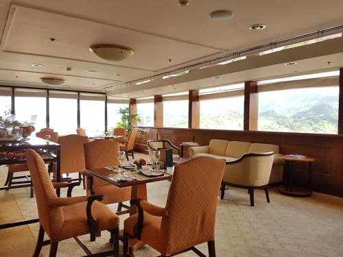 a restaurant with tables and chairs and windows at Marco Polo Plaza Cebu in Cebu City