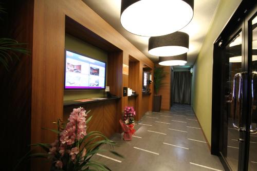 un couloir fleuri et une télévision murale dans l'établissement Dai Tokyo (Adult Only), à Takamatsu