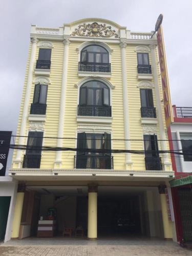 a large yellow building with windows on a street at Bắc Nam Hotel in Da Nang