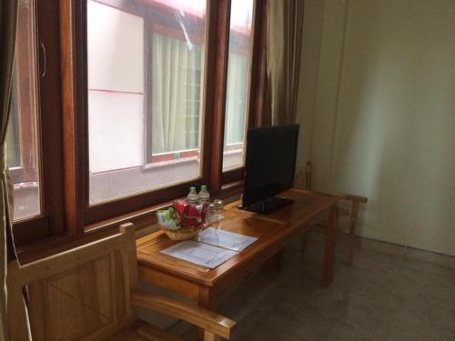 a desk with a computer on it next to a window at Bắc Nam Hotel in Da Nang