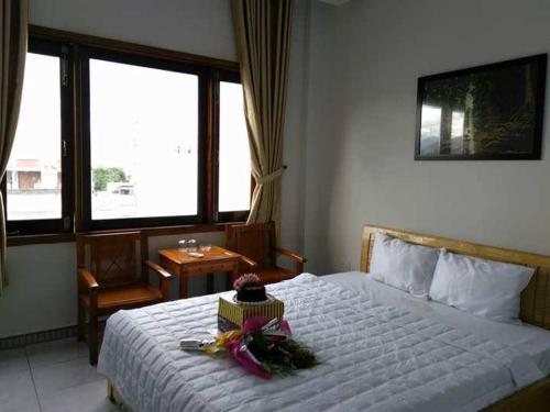 a bedroom with a white bed with flowers on it at Bắc Nam Hotel in Da Nang
