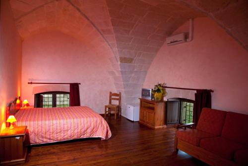 a bedroom with a bed and a couch in a room at B&B Terra Serena in Santa Cesarea Terme
