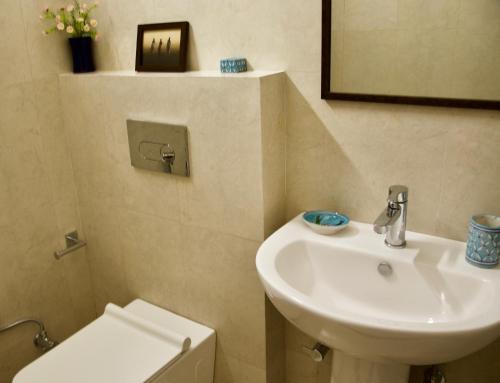 a bathroom with a white sink and a toilet at Pathik Niwas in Jaipur