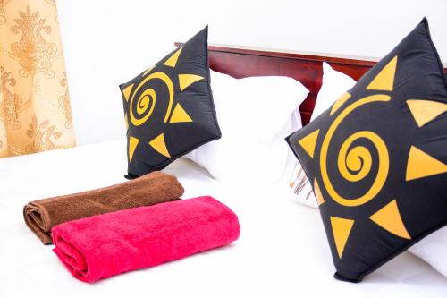 a bed with two pillows and two towels on it at Marcelin Family Villa in Negombo
