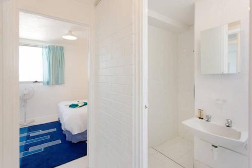 a white bathroom with a bed and a sink at Ocean Harbour Views in Fremantle
