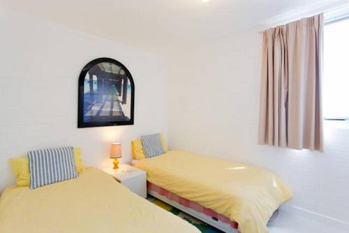 a bedroom with two beds and a window and a mirror at Ocean Harbour Views in Fremantle