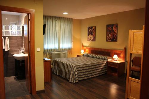 una camera d'albergo con letto e lavandino di Hotel El Tablazo a Villalba de la Sierra