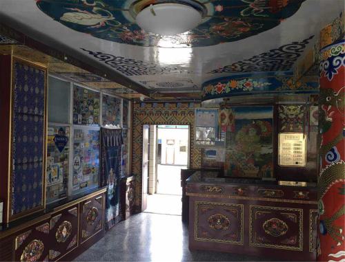 a room with a ceiling with paintings on the walls at Overseas Tibetan Hotel in Xiahe