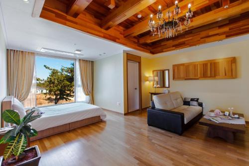 um quarto com uma cama e um sofá em Harmony Resort em Jeju