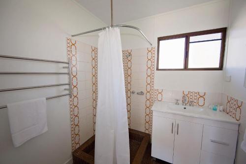 Un baño con cortina de ducha y lavabo. en Apollo Jewel Beachfront Apartments, en South Mission Beach