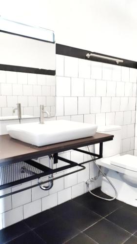 a bathroom with two sinks and a toilet at BY Hotel Kanchanaburi in Kanchanaburi