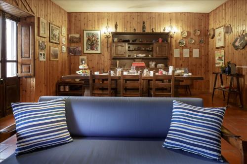 a living room with a blue couch and a table at B&B Gennarcu in Ussàssai