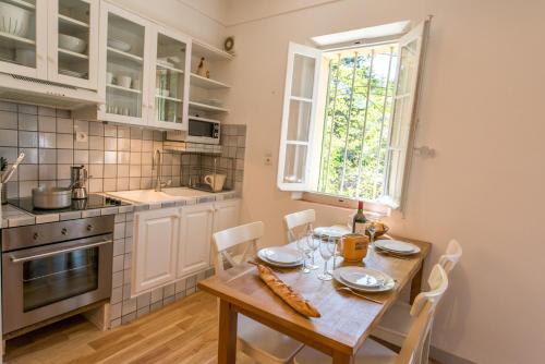una cocina con una mesa de madera con sillas y una ventana en Grand Balaguier, en La Seyne-sur-Mer