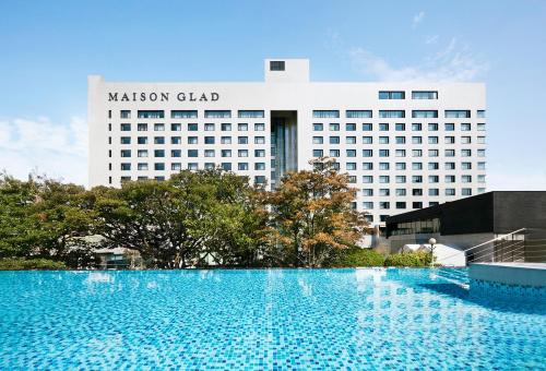 una grande piscina di fronte a un hotel della cappella di Malcolm di Maison Glad Jeju a Jeju