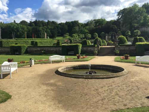 a fountain in the middle of a park with two benches at Kurhotel Fürstenhof by David in Blankenburg