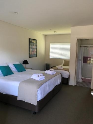 a hotel room with two beds with towels on them at Thirroul Beach Motel in Wollongong