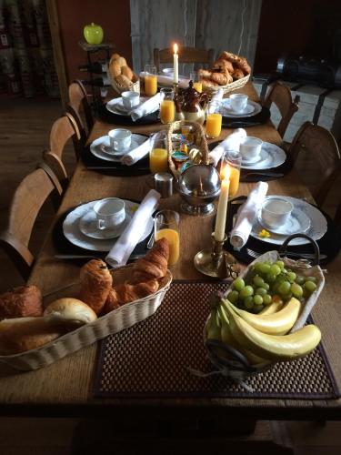 a long table with bread and fruit on it at Guest house Western-city in Chaudfontaine