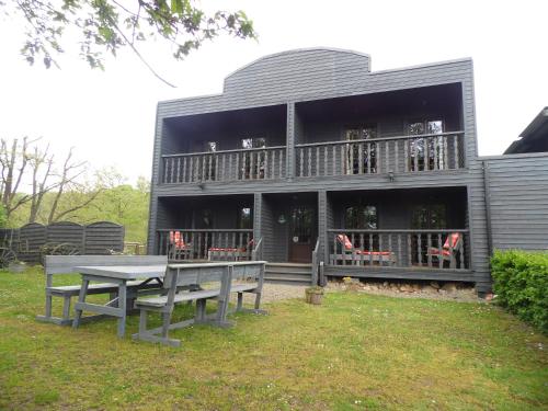 a house with a table and benches in front of it at Guest house Western-city in Chaudfontaine