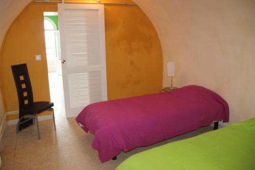 - une chambre avec un lit violet et une chaise dans l'établissement Villa Normande, au Tréport