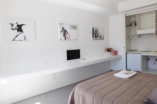 a white room with a bed and a tv at La Chambre in Paola