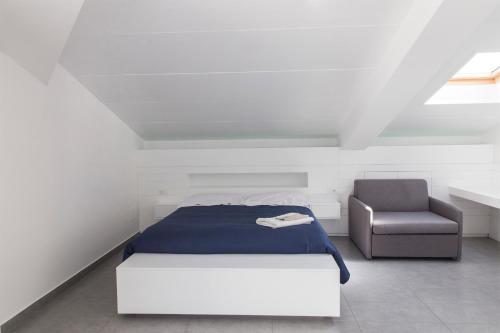 a bedroom with a bed and a chair at La Chambre in Paola
