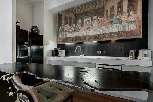 una cucina con tavolo nero e lavandino di Milano Central Luxury a Milano