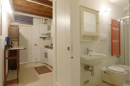 a white bathroom with a sink and a toilet at Salizada San Francesco in Venice