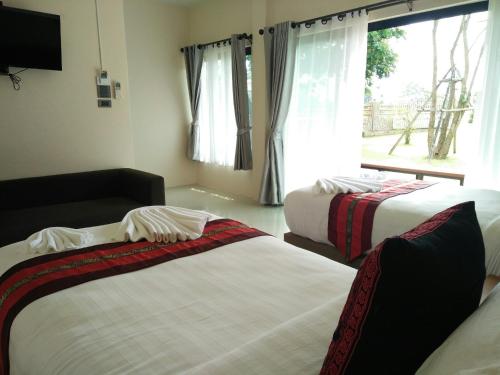 A bed or beds in a room at Lampang Green Garden Resort