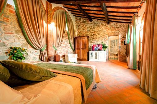 a bedroom with a bed and a stone wall at Il Giuncheto in Trequanda