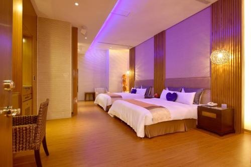 a hotel room with two beds with purple lighting at Norway Forest Villa Motel in Taipei