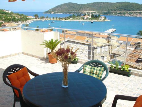 a table with a vase of flowers on a balcony at Apartment II Radisic beautiful view in Vis