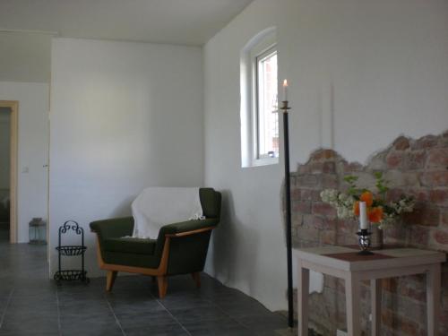 a living room with a green chair and a window at Ola-Nils Gård in Borrby