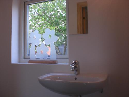 a bathroom with a sink and a window at Ola-Nils Gård in Borrby